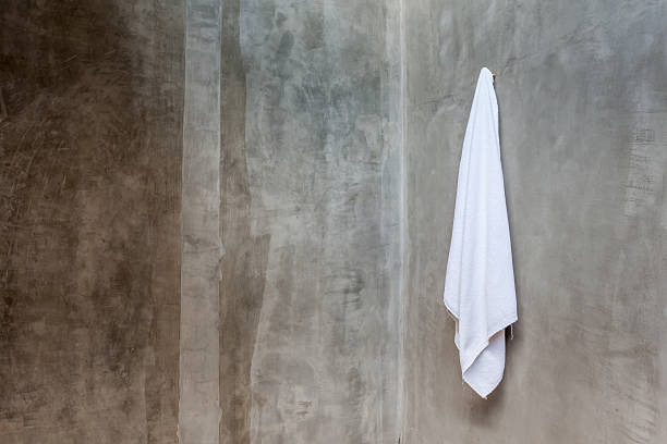 istock White towel is hanging on a hanger with concrete wall. 484534110