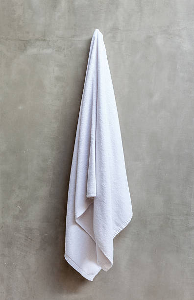 istock White towel is hanging on the exposed concrete wall. 484535036
