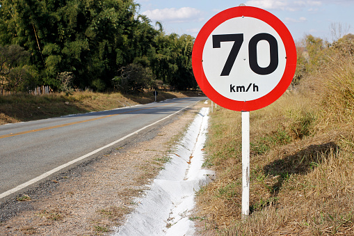 Regulatory board speed of seventy kilometers per hour on paved rural road.