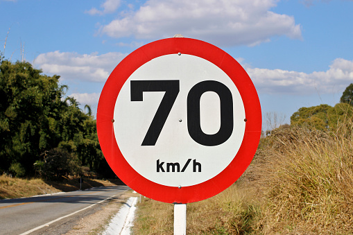 Regulatory board speed of seventy kilometers per hour on paved rural road.