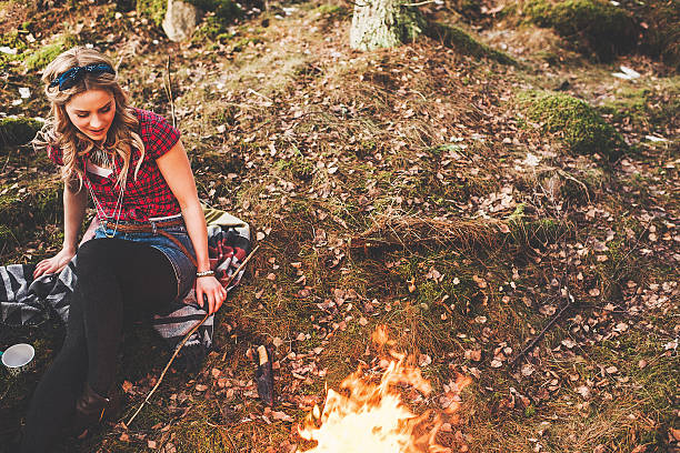 istock Woman by a campfire in the forest 484538035