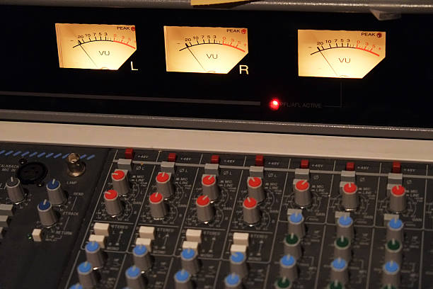 Audio Console Pro audio mixing board viewed at an angle in a recording studio. volume unit meter stock pictures, royalty-free photos & images