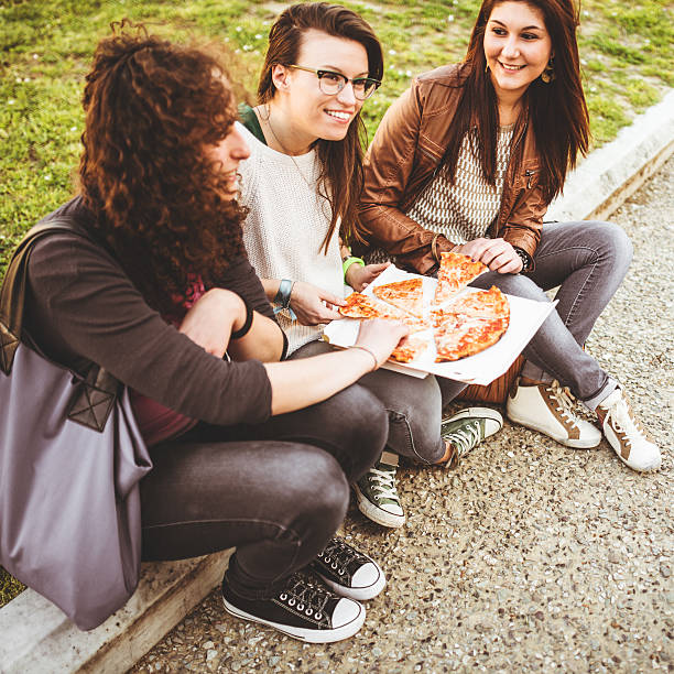 istock group of friends eating pizza togetherness 484541605