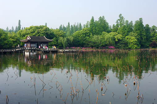 Hangzhou, China - April 24, 2015. Tourists enjoy their times in garden in the middle of West Lake in Hangzhou, China. Hangzhou is the capital city of Zhejiang Province, China, attracting lots of tourists for its beautiful scenery and richness in historic sites.