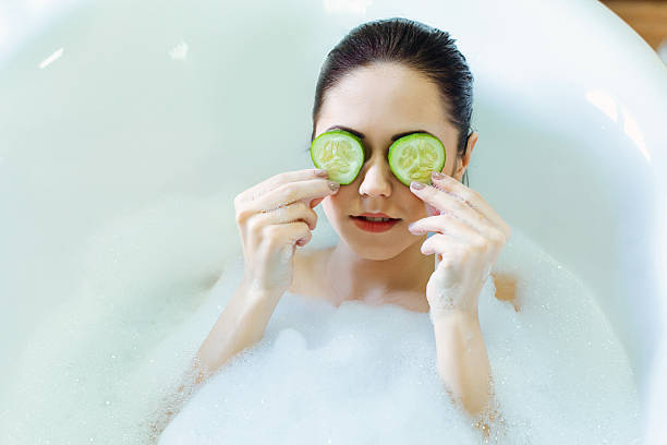istock Woman lying in the bath with cucumber mask 484541813
