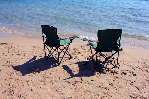 green folding chair on the beach