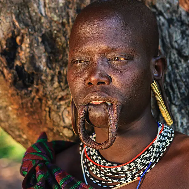 Mursi tribe are probably the last groups in Africa amongst whom it is still the norm for women to wear large pottery or wooden discs or ‘plates’ in their lower lips.http://bhphoto.pl/IS/ethiopia_380.jpg