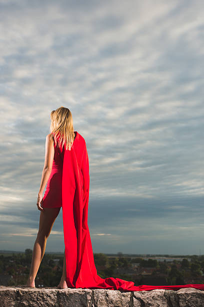 istock Young woman posing as superhero over blue sky 484552466