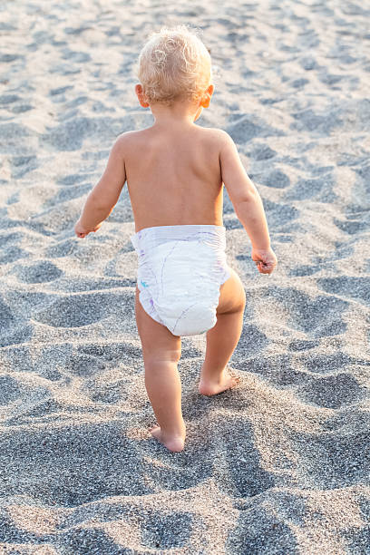 istock Cute little child in pampers from his back going ahead 484552634