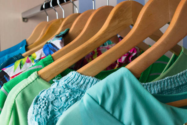 istock Colored female clothes on hangers in wardrobe 484553872