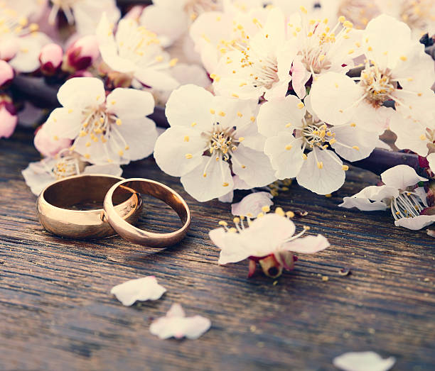 istock Wedding rings. Spring. Flowering branch on wooden surface 484554906
