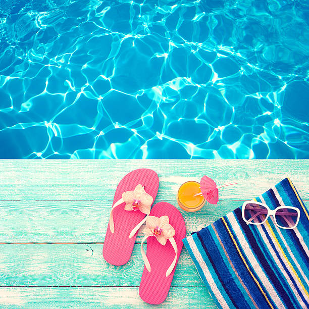 istock Summer vacation. Pink sandals by swimming pool 484556326