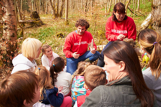 Adults And Children Examining Bird's Nest At Activity Centre stock photo