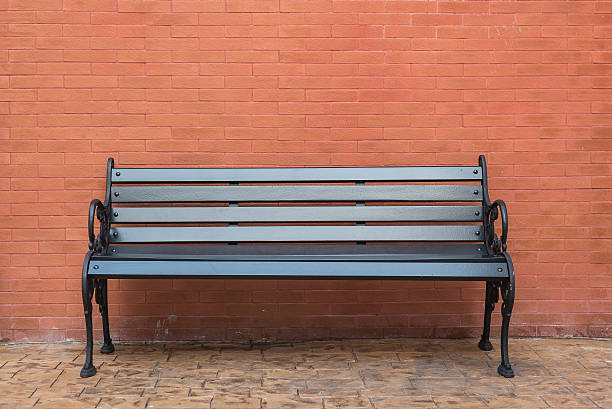 istock black wooden classic bench with brick wall 484559186