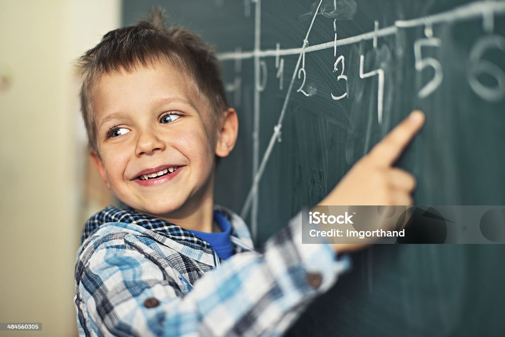 Math is fun Cute little boy in math class, poining at the blackboard. 4-5 Years Stock Photo