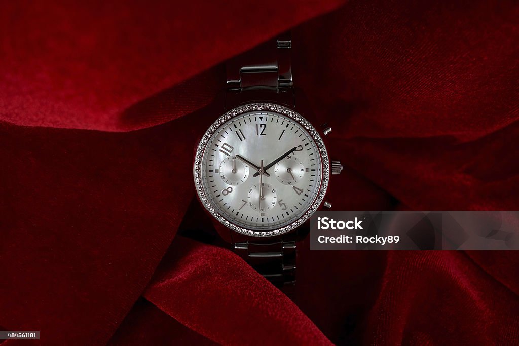 Luxury wrist watch on red velvet Luxurious wrist watch for women on red velvet - perfect present for mother's day. This watch has a dial made of mother of pearl and a bezel full of diamonds. ALL LABELS ARE REMOVED! Luxury Stock Photo