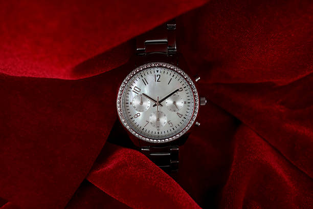 Luxury wrist watch on red velvet Luxurious wrist watch for women on red velvet - perfect present for mother's day. This watch has a dial made of mother of pearl and a bezel full of diamonds. ALL LABELS ARE REMOVED! perfect gift stock pictures, royalty-free photos & images