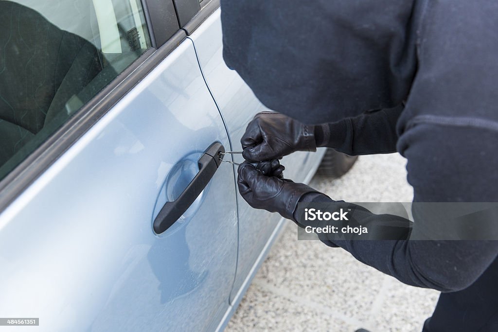 Car thief using  special tools to brake into a car Aggression Stock Photo