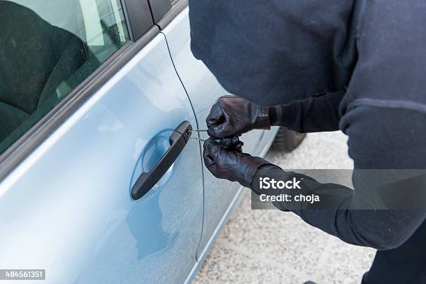 Car Thief Using Special Tools To Brake Into A Car Stock Photo - Download Image Now - Aggression, Burglar, Burglary