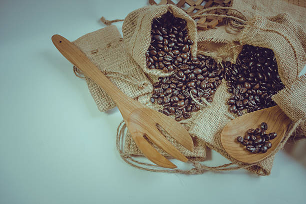 istock Coffee beans wooden spoon and fork on sack surface. 484562760