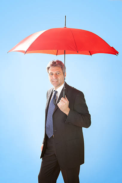 istock Senior businessmen holding a umbrella 484563296
