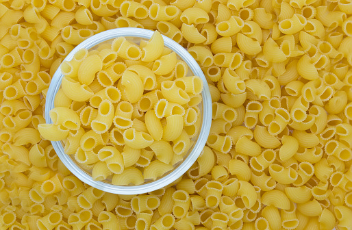 Macaroni in the glass bowl and background, Isolated