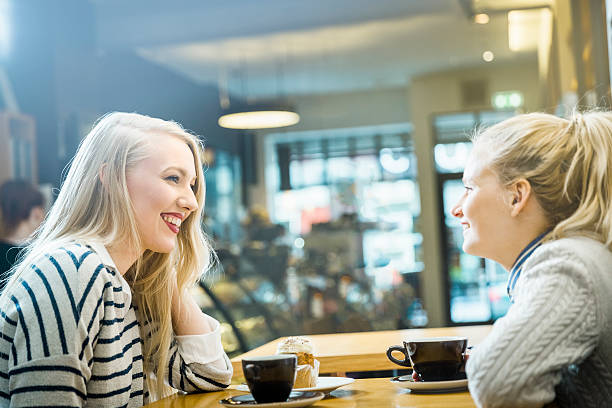 istock Smiling women looking at each other in cafe 484567266