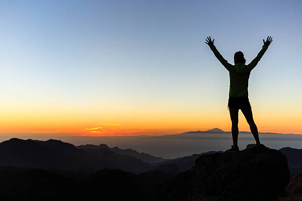 Climber success silhouette, inspiration and motivation Woman successful hiking climbing silhouette in mountains, motivation and inspiration in beautiful sunset and ocean. Female hiker with arms up outstretched on mountain top looking at beautiful night sunset inspirational landscape. atlantic islands photos stock pictures, royalty-free photos & images
