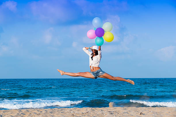 istock Young woman jumping with  balloons 484573476