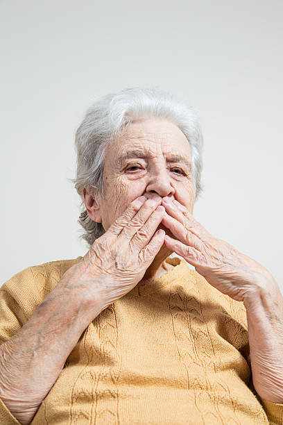 istock senior woman closing her mouth 484573970