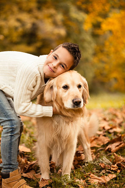 istock Boy embracing his dog in the park 484573998