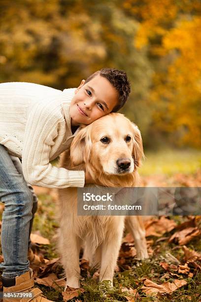 Boy Embracing His Dog In The Park Stock Photo - Download Image Now - Autumn, Falling, Teenager