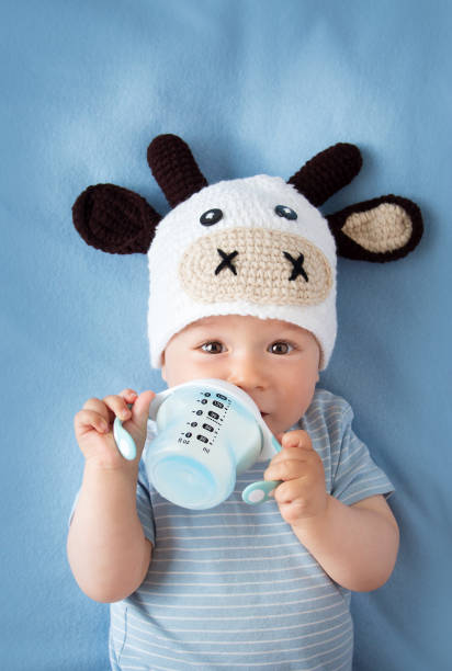 istock Baby in a cow hat drinking milk 484575112