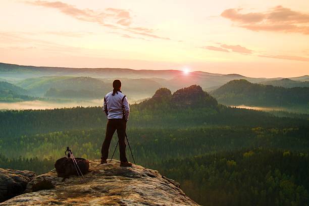 istock Photographer in white jacket  takes photos with camera on tripod 484576312