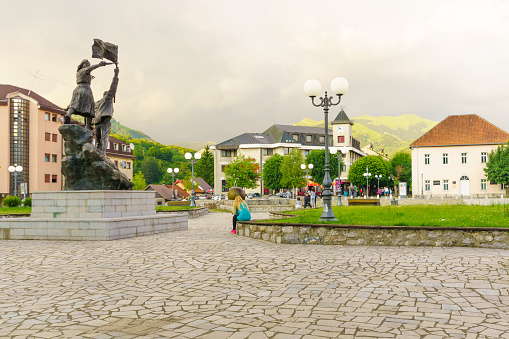 Kolasin, Montenegro - June 30, 2015: Scene of Trg Borca square, with the Partisans Monument, locals and tourists, in Kolasin, Montenegro