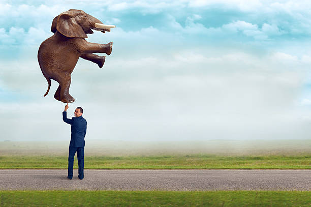 istock businessman holding an elephant with one finger 484581066