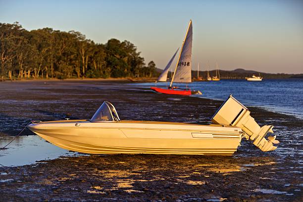 Speedboat on shore at low tide stock photo