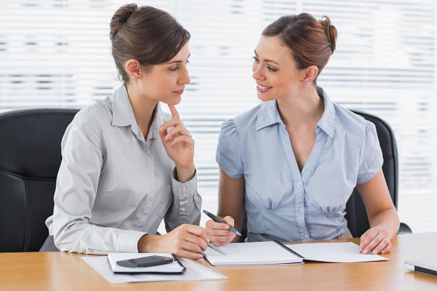 istock Smiling businesswomen working together on documents 484582865
