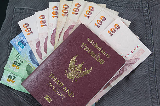 Thai money with thai passport holiday stock photo