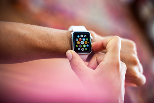 Rome, Italy - August 17, 2015:  Apple Watch Sport model being worn on a girl's left wrist. This smartwatch has a 38 mm screen in a silver aluminium case with a white, soft plastic sports band. Released on Friday April 24, 2015 the display shows apps available on the watch.