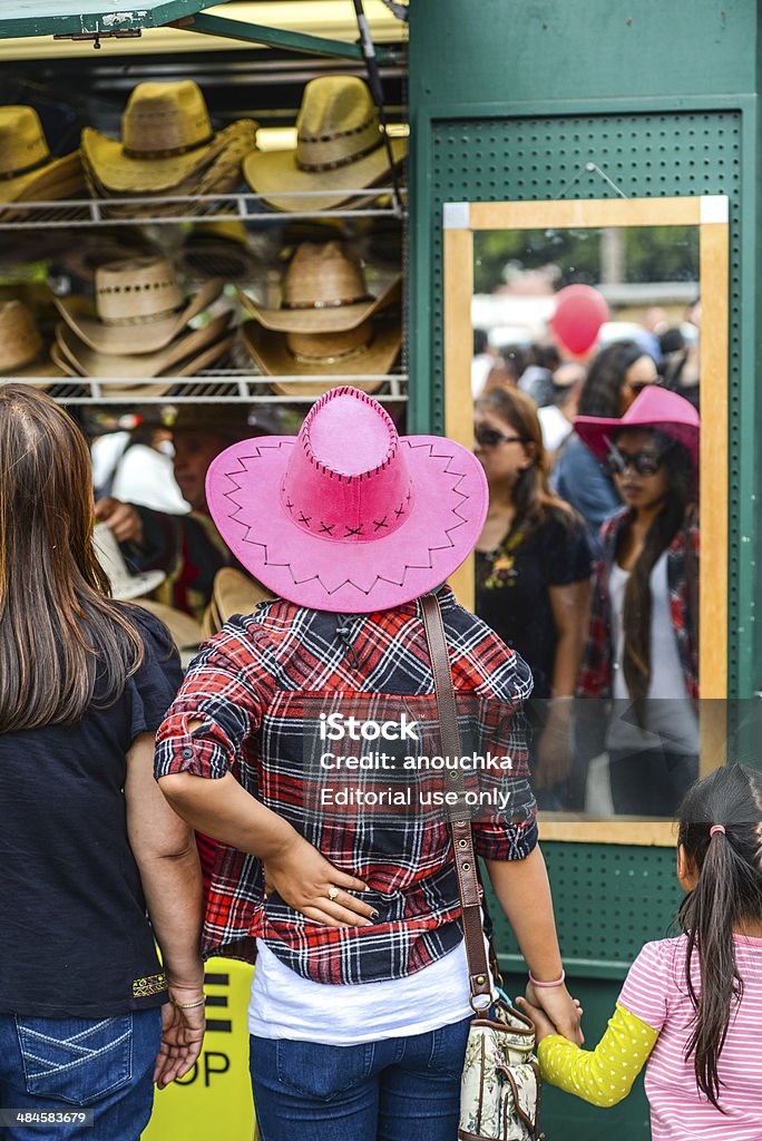 Cinco De Mayo Celebration in Los Angeles, USA Los Angeles, USA - May 5, 2013: Cinco De Mayo Celebration in Los Angeles, USA, crowds of people in El Pueblo district of Los Angeles, decorated for a holiday. People buying and trying colorful traditional hats. Woman wearing pink sombrero holding hands with little girl Adult Stock Photo