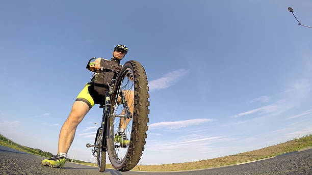 istock Mountain biker on the tarmac. Blue sky. 484584306