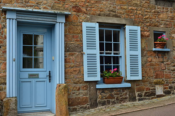 Jersey, U.K. - August 17, 2015: A traditional 19th century cottage on the St Aubin high street built on a sloping hill near the harbour.