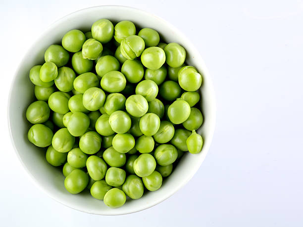 istock Green peas in the bowl isolated on white 484594476