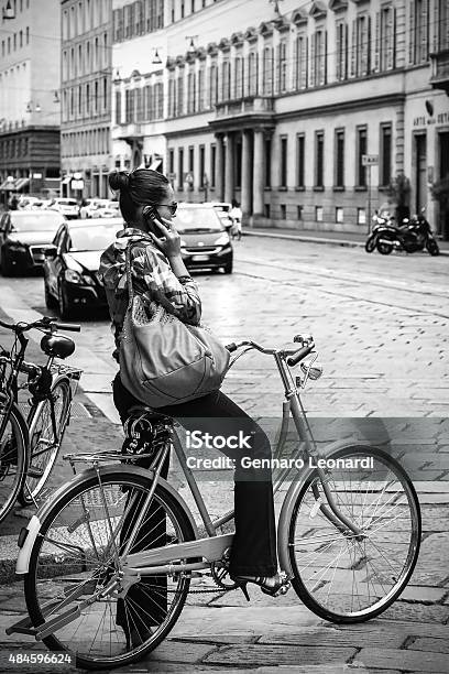 Woman Cycling In Milan Stock Photo - Download Image Now - 2015, Adult, Architecture