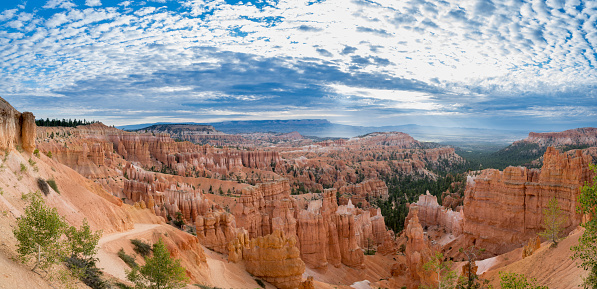 Bryce Canyon morning panorama as some unique clouds rolled in overhead creating sunbeams down into the canyon.