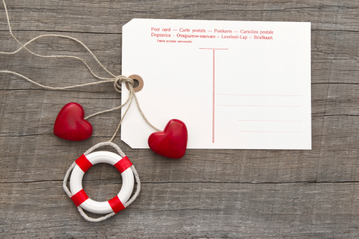 Post card for message with two red hearts and lifebuoy on grey wooden background for holiday greetings, valentine's day, mother's day, birthday or anniversary - greeting card