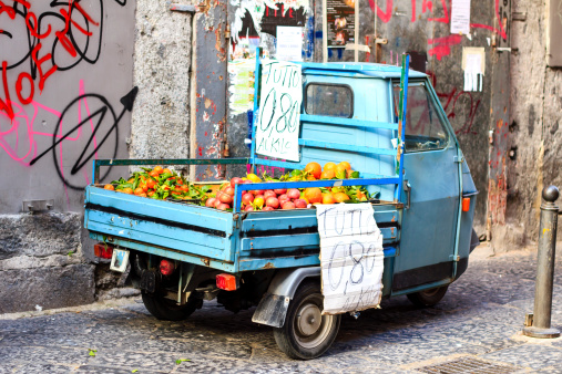 Fruits sold from the old blue mini-truck at the small street of Naples, Italy