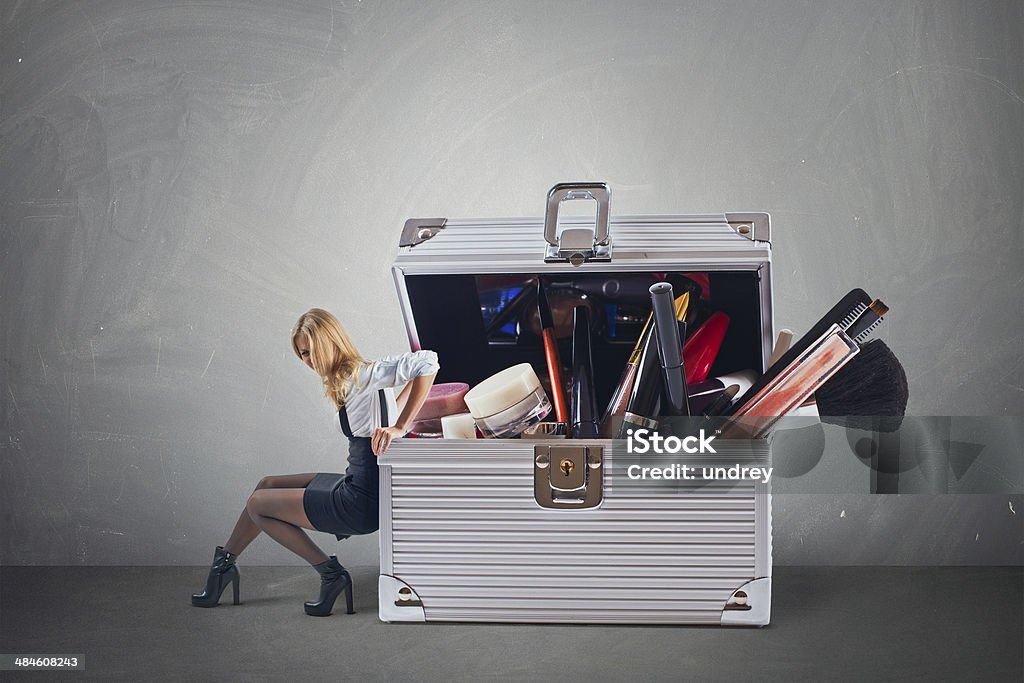 Young attractive woman pushing big hevy case with cosmetics Young attractive woman pushing big hevy case with cosmetics with some difficulty Bag Stock Photo