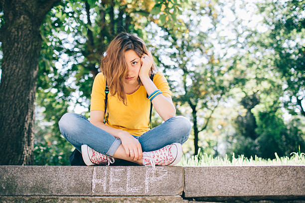 Unahppy teenager outside Teenage girl feeling depressed in the park message of nature stock pictures, royalty-free photos & images
